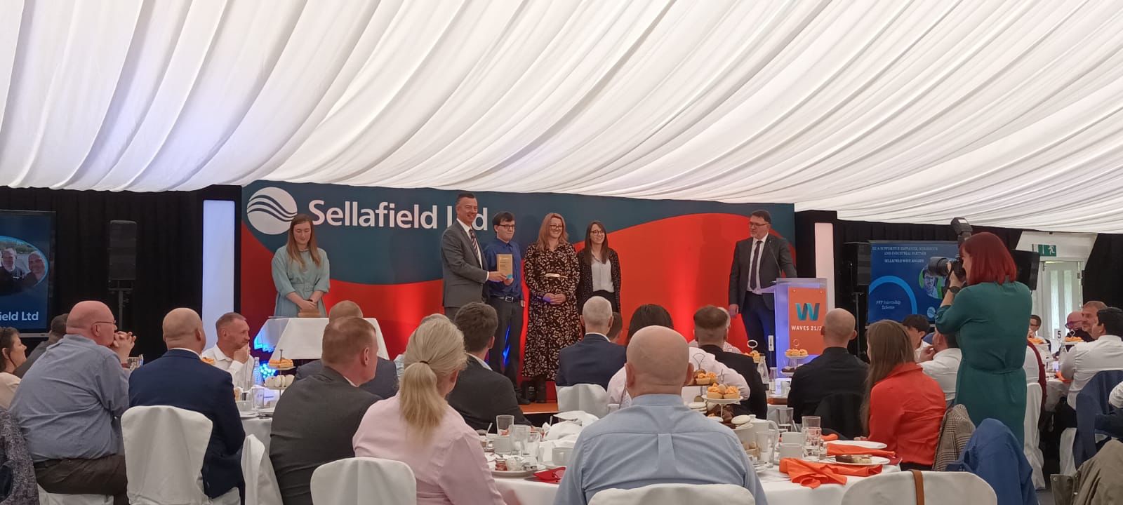 Pictured L-R: Sellafield Ltd CEO Martin Chown presenting John Atkinson (KBR Intern), Caroline Hindmarch (PPP Internship Scheme Lead) and Kathryn Ambrose (Sellafield Ltd Social Impact Lead) with a Sellafield Wave Award.