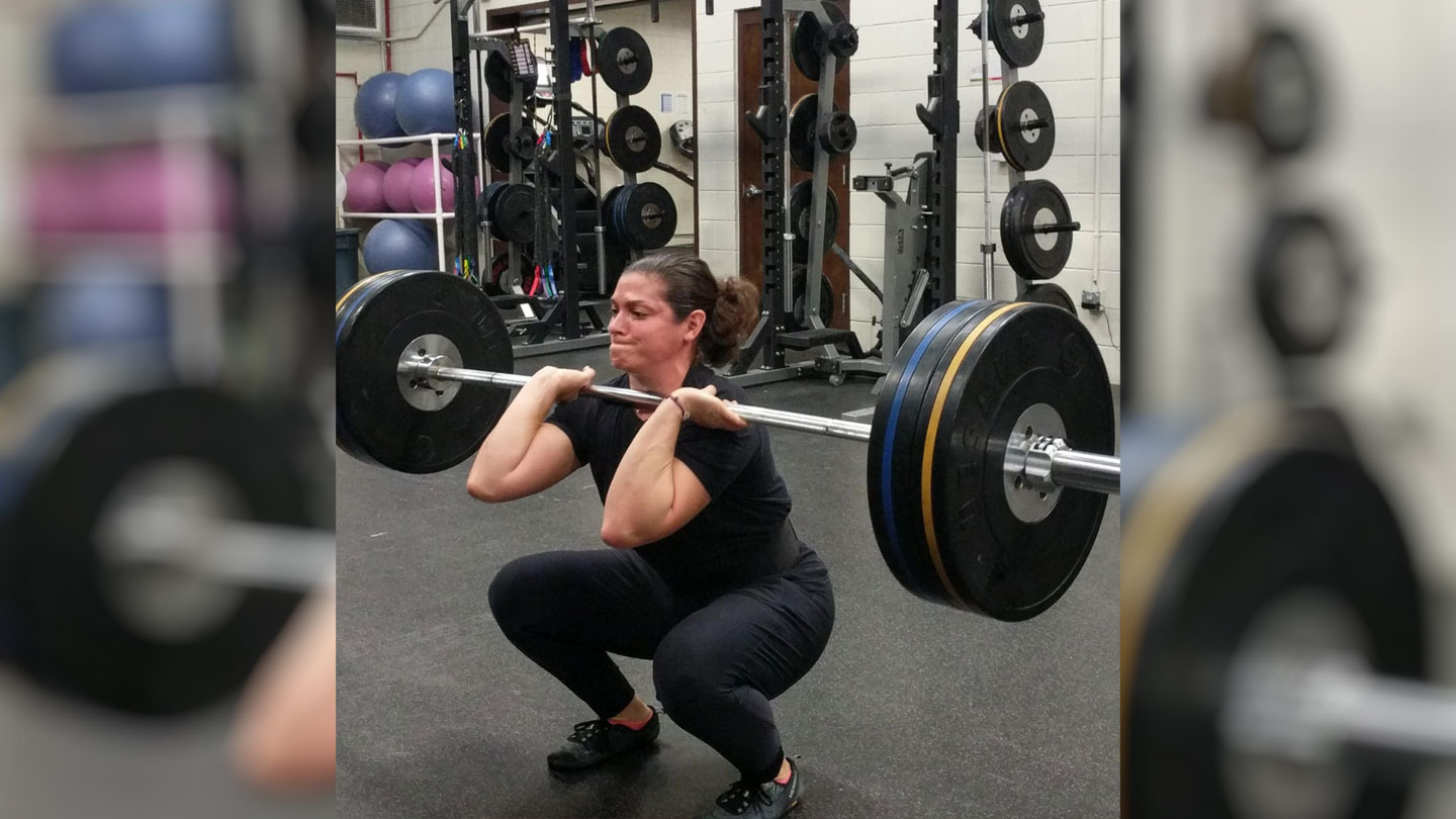 Strength and Conditioning Coach Maureen Khairallah demonstrates proper weight training form as a strength and conditioning coach for Army Special Forces.
